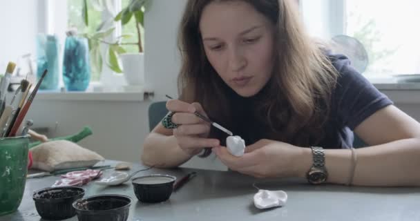 Donna rendendo bambola parte in ceramica. Femmina seduta e creando orecchio per bambola a casa a tavola. Parti di bambole di ceramica, abilità fatte a mano e creative — Video Stock