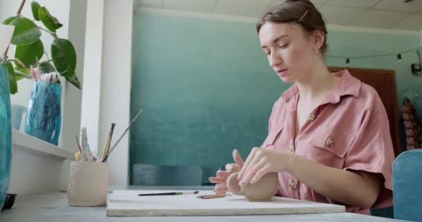 Female potter sitting and makes a cup at the table. Woman making ceramic item. Pottery working, handmade and creative skills — Stock Video