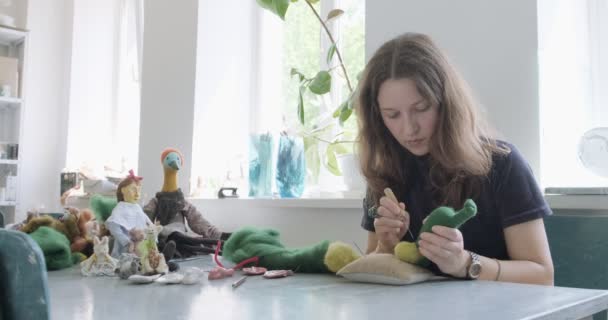 Femme faisant jouet de poupée d'art de laine à la table. Femme assise et créant une poupée ooak à la maison. Aiguille feutrée Compétences artisanales et créatives — Video