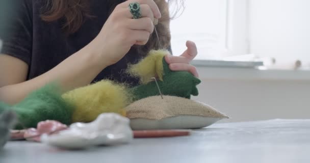 Mujer haciendo lana arte muñeca juguete en la mesa de cerca. Mujer sentada y creando ooak muñeca en casa. Aguja fieltro Habilidades hechas a mano y creativas — Vídeo de stock