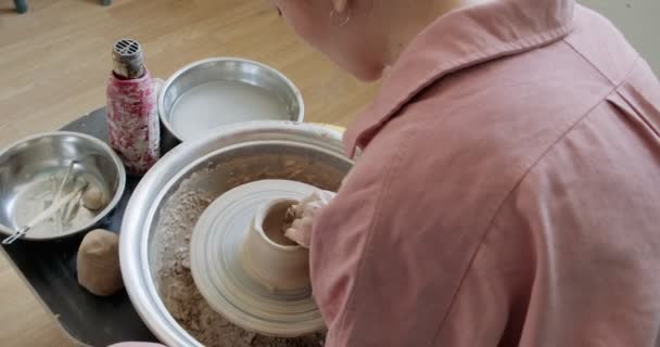 Žena hrnčíř sedí a dělá šálek na hrnčířském kole. Žena vyrábějící keramické předměty. Pottery working, handmade and creative skills — Stock video