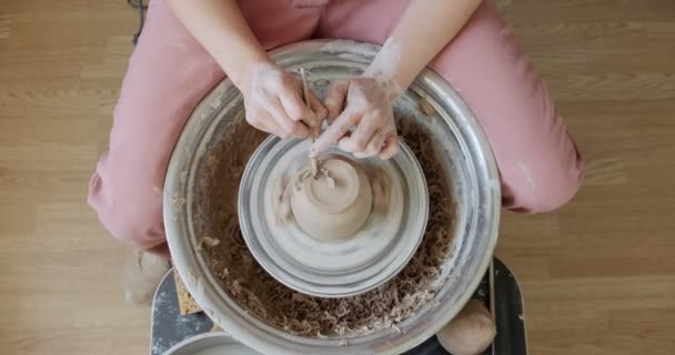 Žena hrnčíř sedí a dělá šálek na hrnčířském kole. Žena vyrábějící keramické předměty. Pottery working, handmade and creative skills — Stock video