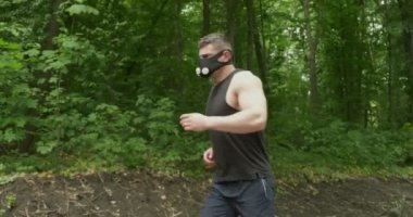 Spor Giyim Maskeli Genç Erkek Ormanda Yolda Koşuyor. Erkekler yoğun idman yapıyor.