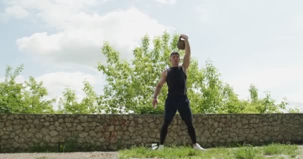 Entrenamiento con pesas, ejercicio intenso de fuerza al aire libre. Los hombres haciendo ejercicio con kettlebell — Vídeos de Stock