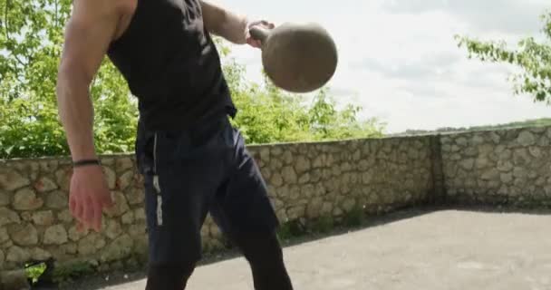 Entrenamiento con pesas, ejercicio intenso de fuerza al aire libre. Los hombres haciendo ejercicio con kettlebell — Vídeos de Stock