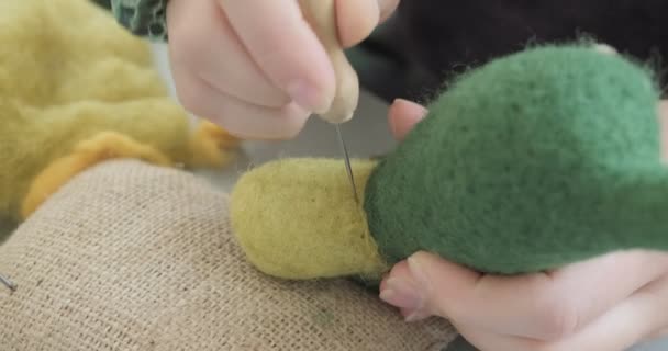 Vrouw maken wol kunst pop speelgoed aan tafel close-up. Vrouwelijke zittende en het creëren van ooak pop thuis. Naaldvilt Handgemaakte en creatieve vaardigheden — Stockvideo