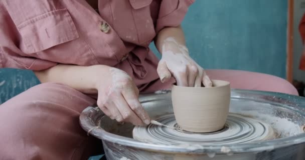 Töpferin sitzt und macht eine Tasse auf der Töpferscheibe. Frau, die Keramik herstellt. Töpfern, handwerkliches und kreatives Geschick — Stockvideo