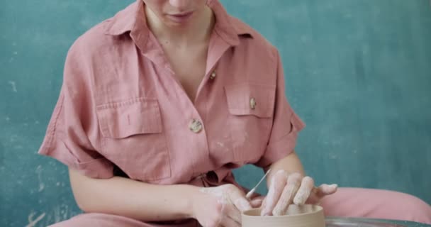 Töpferin sitzt und macht eine Tasse auf der Töpferscheibe. Frau, die Keramik herstellt. Töpfern, handwerkliches und kreatives Geschick — Stockvideo