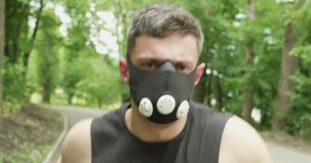 Junger Mann mit Gesichtsmaske in Sportkleidung beim Waldlauf. Männer beim intensiven Lauftraining — Stockvideo