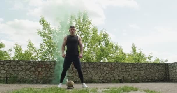 Treino com kettlebells, exercício de força intensa ao ar livre com fundo de fumaça. Os homens ficam com kettlebell — Vídeo de Stock