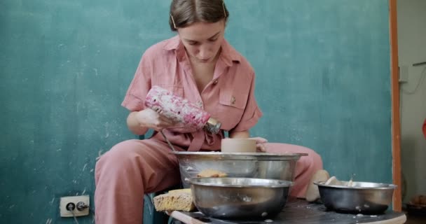 Žena hrnčíř sedí a pálí tvar pohár hlíny na hrnčířském kole. Žena vyrábějící keramické předměty. Palba z hrnce, ruční práce a kreativní dovednosti — Stock video