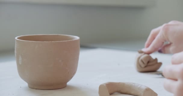 Female potter sitting and makes a cup at the table. Woman making ceramic item. Pottery working, handmade and creative skills — Stock Video