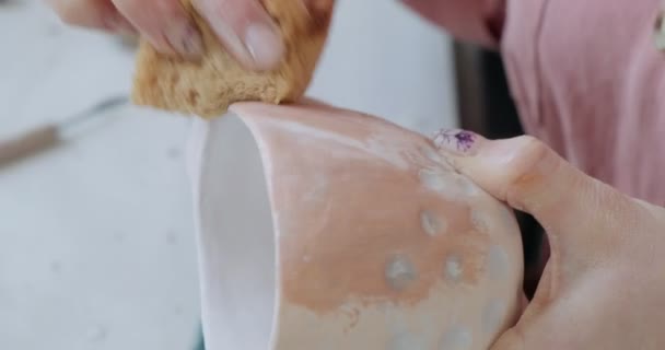 Žena hrnčíř sedí a míchá malovat štětcem pohár na stole. Žena vyrábějící keramické předměty. Pottery working, handmade and creative skills — Stock video