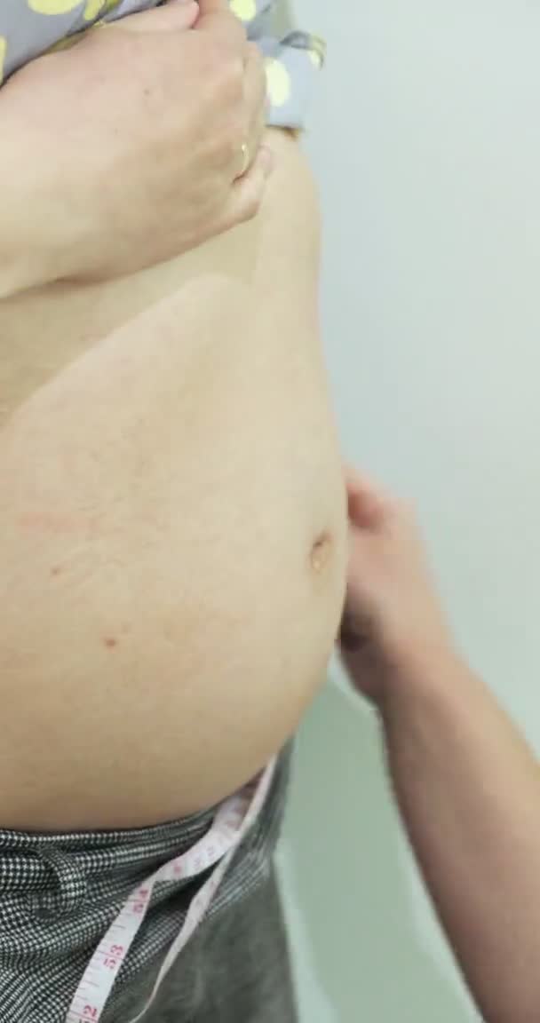 Doutor mede a barriga de uma menina grávida close-up. Perímetro da barriga das mulheres grávidas — Vídeo de Stock