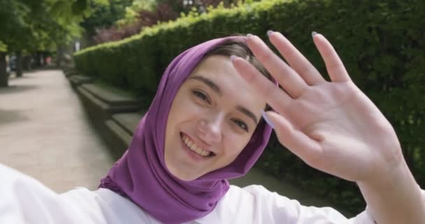 Smuk ung kvinde, der har videoopkald ved hjælp af kamera ser på smartphone, iført traditionelle tørklæde. Attraktiv Kvinde i hijab – Stock-video