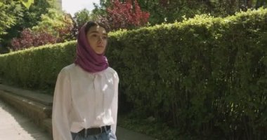 Güzel genç bir kadın geleneksel türban takarak sokakta yürüyor. Türbanlı çekici kadın.