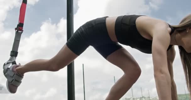 Mulher bonita faz treinamento com tiras de fitness ao ar livre. Atraente Treinamento feminino — Vídeo de Stock