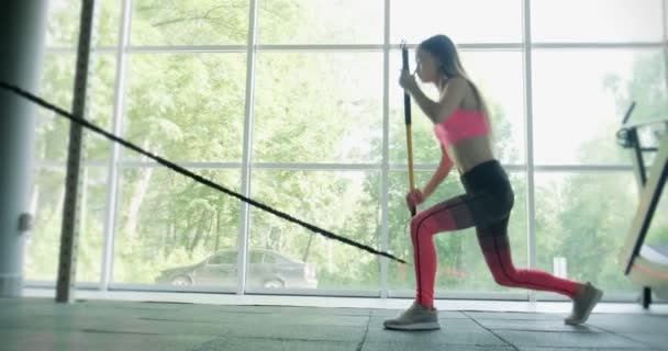 Mulher bonita faz treinamento com barra ponderada no ginásio. Atraente Treinamento feminino — Vídeo de Stock