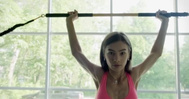 Hermosa mujer joven hace entrenamiento con barra ponderada en el gimnasio. Atractivo entrenamiento femenino — Vídeos de Stock