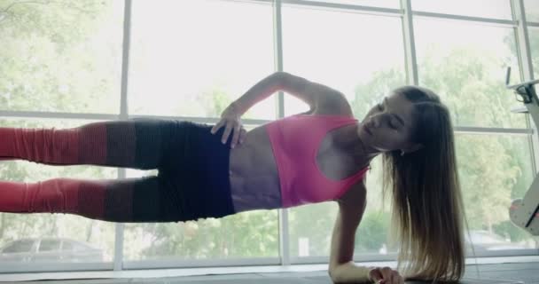 Красивая молодая женщина тренируется с фитнес-ремнями в тренажерном зале. Привлекательная женская тренировка — стоковое видео