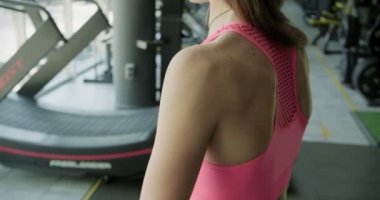 Güzel genç bir kadın spor salonunda ağırlık ölçer ile antrenman yapıyor. Çekici Kadın Eğitimi