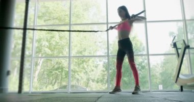 Güzel genç bir kadın spor salonunda ağırlık ölçer ile antrenman yapıyor. Çekici Kadın Eğitimi