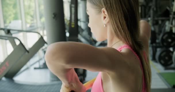 Hermosa mujer joven hace entrenamiento con barra ponderada en el gimnasio. Atractivo entrenamiento femenino — Vídeos de Stock