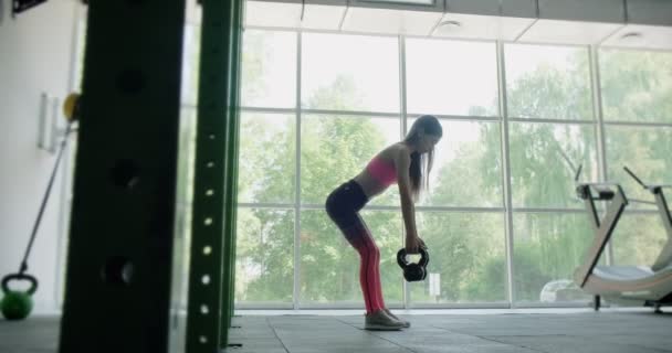 Bella giovane donna fa allenamento con kettlebell in palestra. Attraente formazione femminile — Video Stock