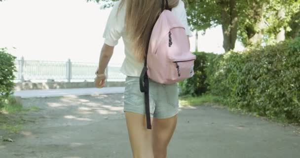 Jovem turista feliz andando rua calçadão. Menina atlética atraente ir para treinamento esportivo com saco. Aproveite o dia de verão — Vídeo de Stock