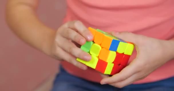 Niño recoge rompecabezas cubo Rubiks — Vídeos de Stock