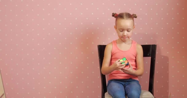 Bambino raccoglie puzzle Rubiks cubo — Video Stock
