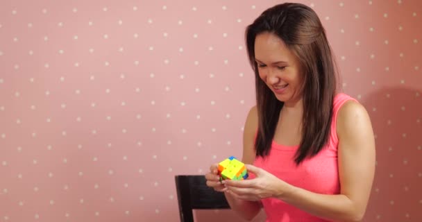 Dívka sbírá puzzle Rubiks kostka — Stock video