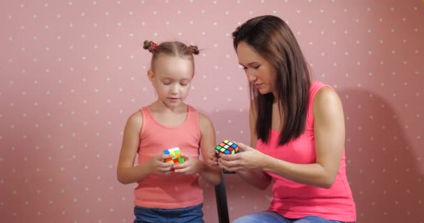 Barnet lär montering av pusslet Rubiks kub — Stockvideo