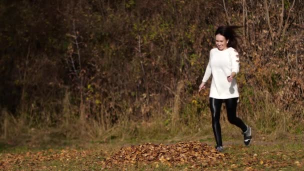 Glückliches Mädchen mit Blättern im Park. gelbes Laub — Stockvideo