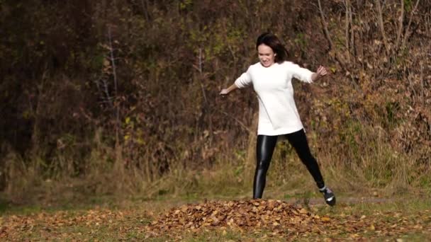 Glad tjej med blad i parken. Gula blad — Stockvideo