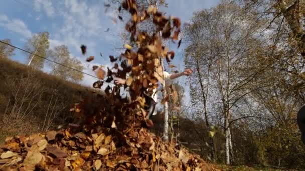 Glückliches Mädchen mit Blättern im Park. gelbes Laub — Stockvideo