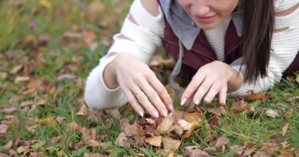 Mutlu kız parkta çim üzerinde yalan. Sarı yapraklar — Stok video