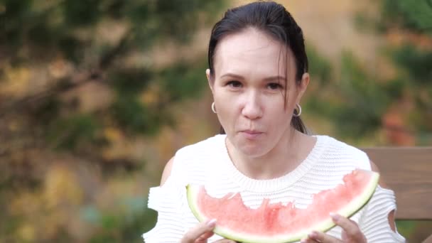 Mädchen beim Wassermelonenessen im Park. Video in Zeitlupe. das Konzept des Mädchens und der Wassermelone — Stockvideo