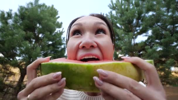 Girl eating watermelon in the Park. slow motion video lifestyle. the concept of the girl and the watermelon — Stock Video