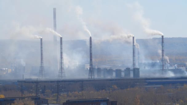 Промышленная зона с трубкой из густого дыма, вылитой из труб завода . — стоковое видео