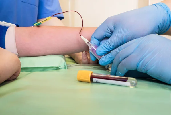 Enfermera que toma muestras de sangre de la vena de un niño — Foto de Stock