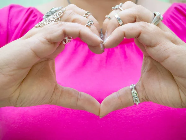 Gros plan des mains d'une femme avec de nombreux beaux anneaux en forme de coeur — Photo