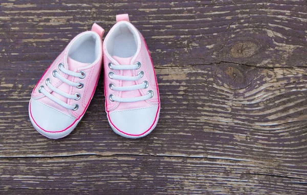 Bebé niña zapatos rosados sobre fondo de madera — Foto de Stock