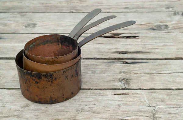 Antieke roestige koperen potten op houten ondergrond — Stockfoto