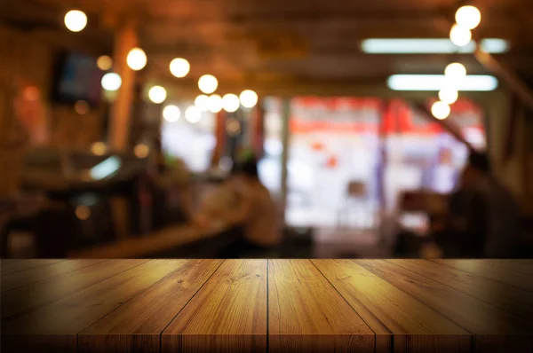 空木製テーブルの上のコーヒー ショップやレストランのインテリア背景をぼかした写真. — ストック写真