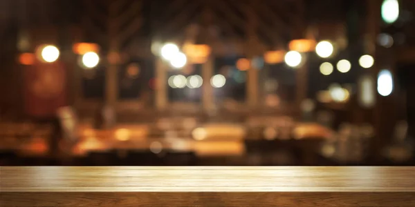Prázdnou dřevěný stůl top s rozostření kavárně nebo restauraci interiérových pozadí. — Stock fotografie