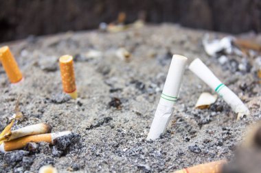 kirli bir kül tablası içinde sigara füme