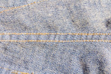 kot ahşap bir arka plan üzerine yığılmış. Kahverengi ahşap arka plan üzerinde kot pantolon. Yıpranmış kot pantolon. Vintage tarzı deri kemer ile güzel mavi kot detay. Kot pantolon arka plan doku