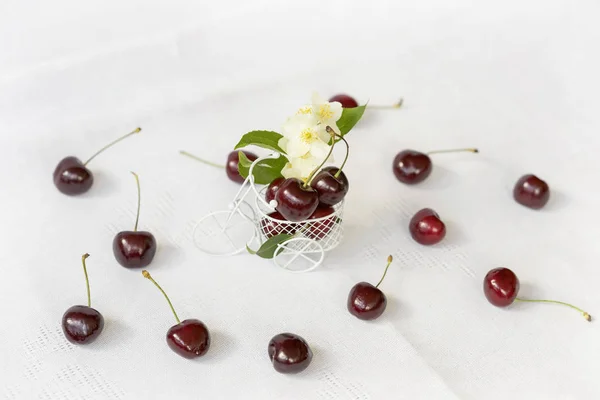 Cerejas maduras em brinquedo em miniatura, trole closeup, fundo claro, baga orgânica, flores, folhas, vista superior. Conceito de comida saudável, desintoxicação, vitaminas, dieta, verão — Fotografia de Stock