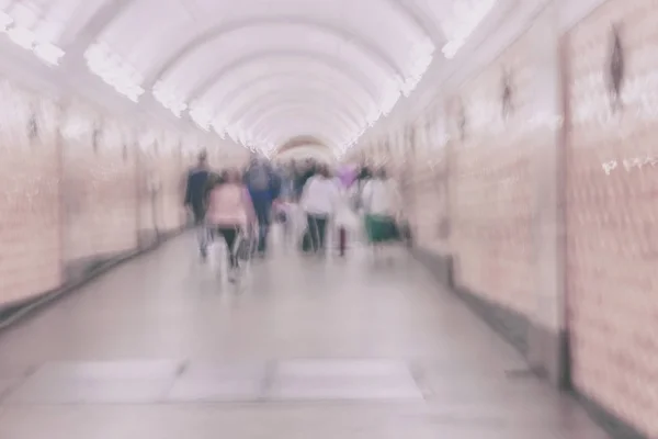 Un grupo irreconocible de personas en el corredor arqueado. Fondo abstracto borroso, tonos claros —  Fotos de Stock